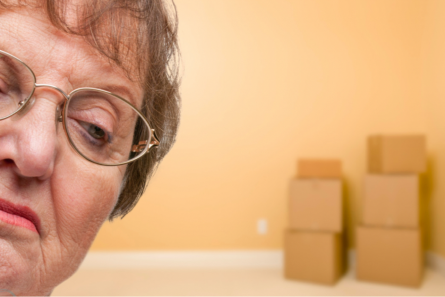 imagen de la cara de una señora con cajas de mudanza al fondo
